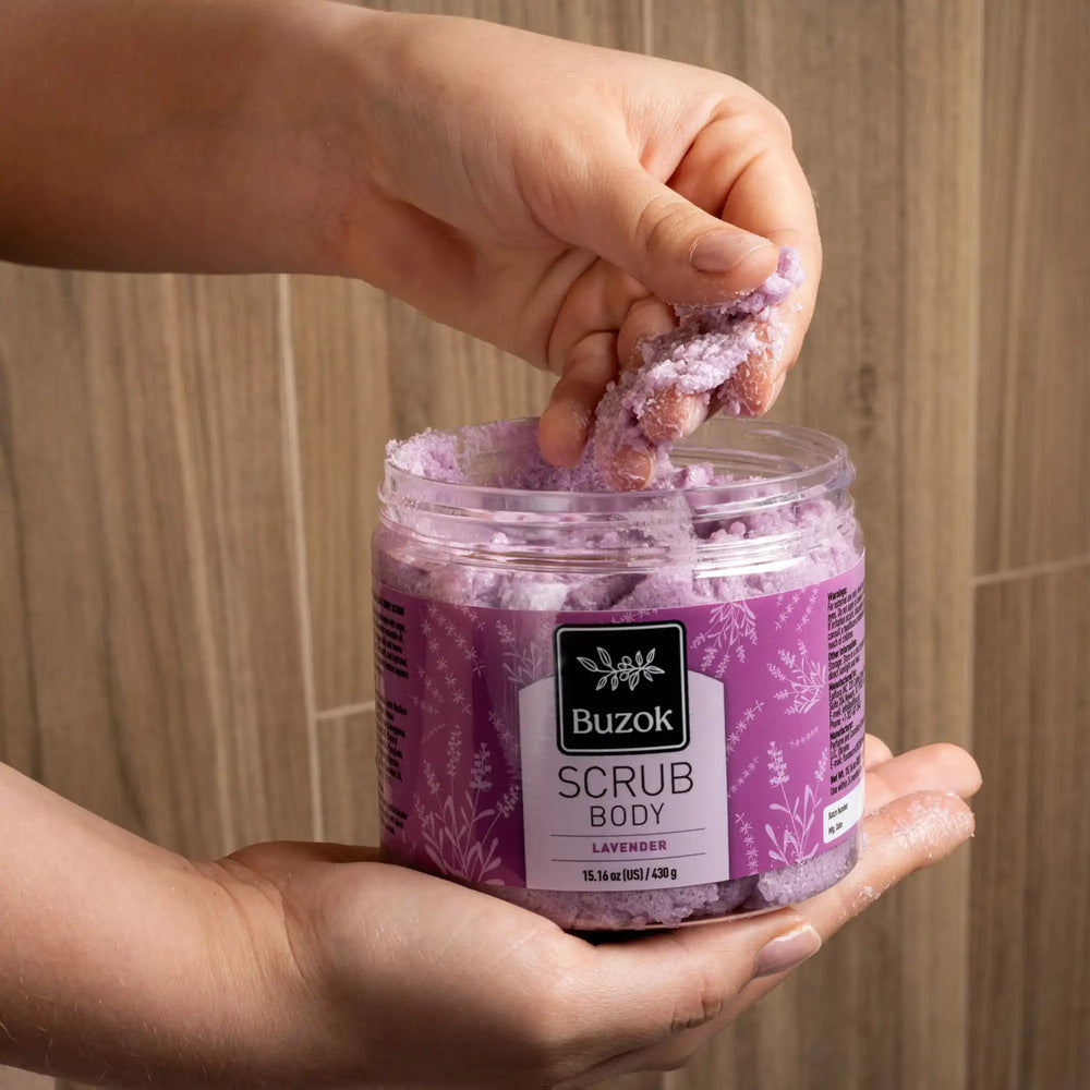 Person holding a jar of Buzok lavender scrub with a wooden background